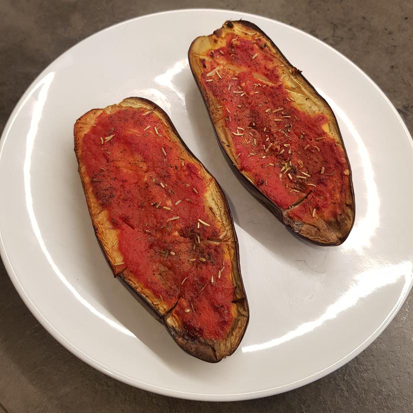 Aubergines à la tomate cuite, déposé dans une assiette, prête a être dégusté