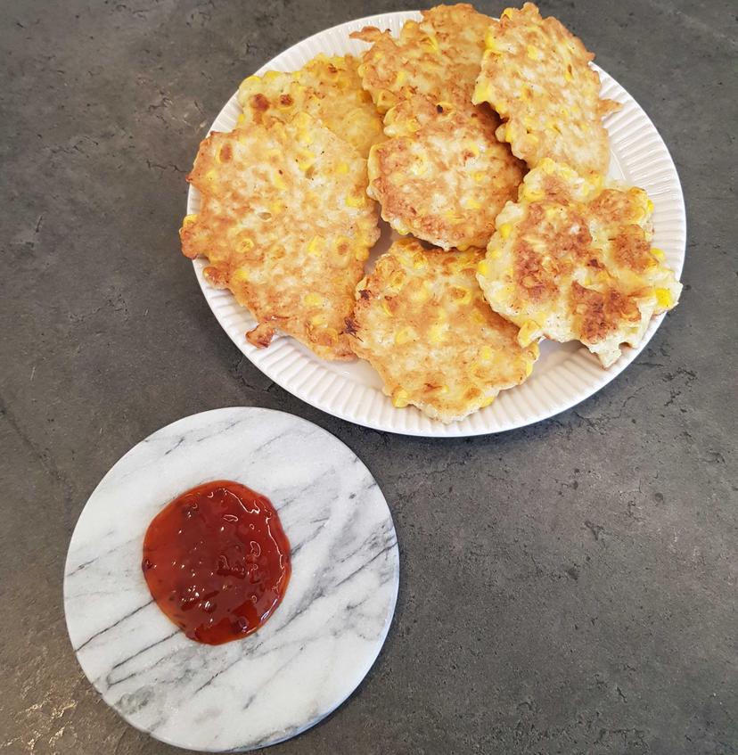 Galettes de maïs dans une assiette avec de la sauce aigre-douce déposé sur le côté 