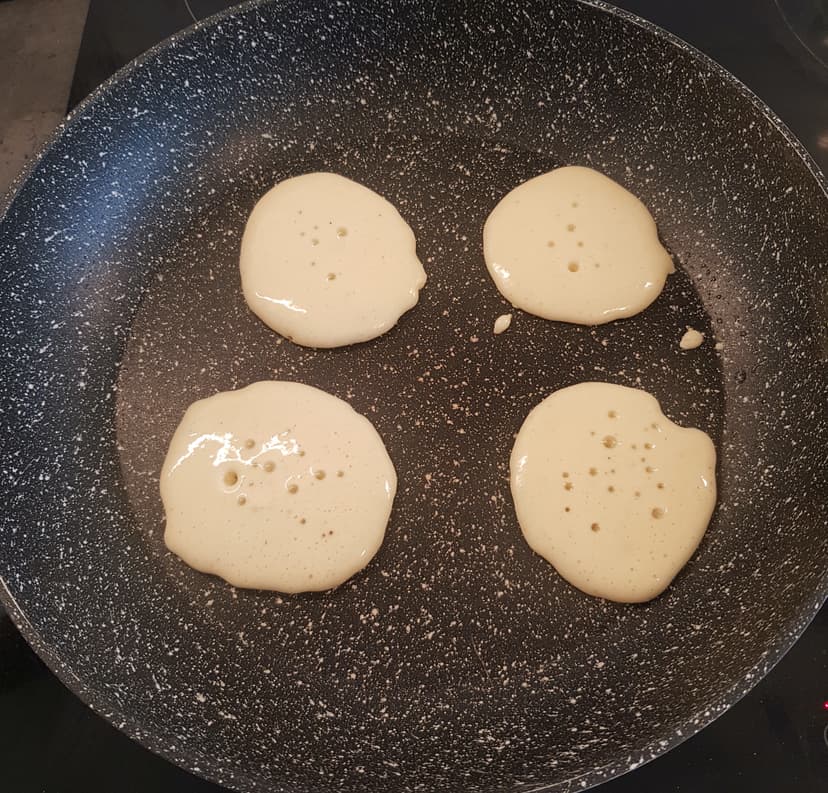 Préparation à blinis versé dans une poêle chaude et huilé avec une louche en petit cercle