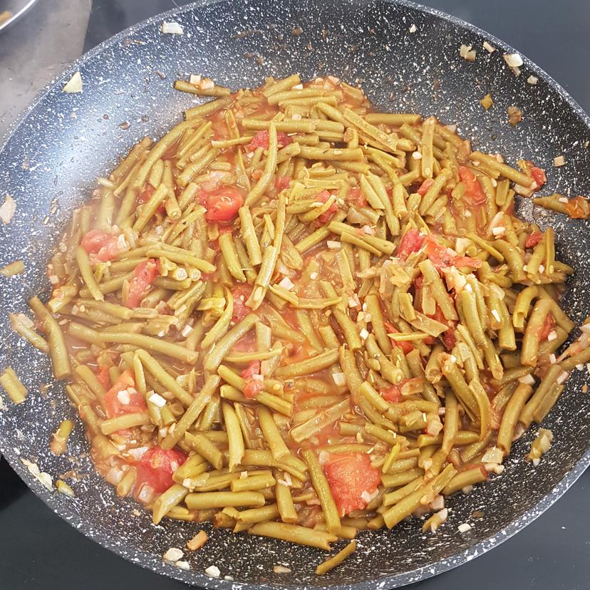 Haricots en train de mijoter avec les tomates et l'assaisonnement 