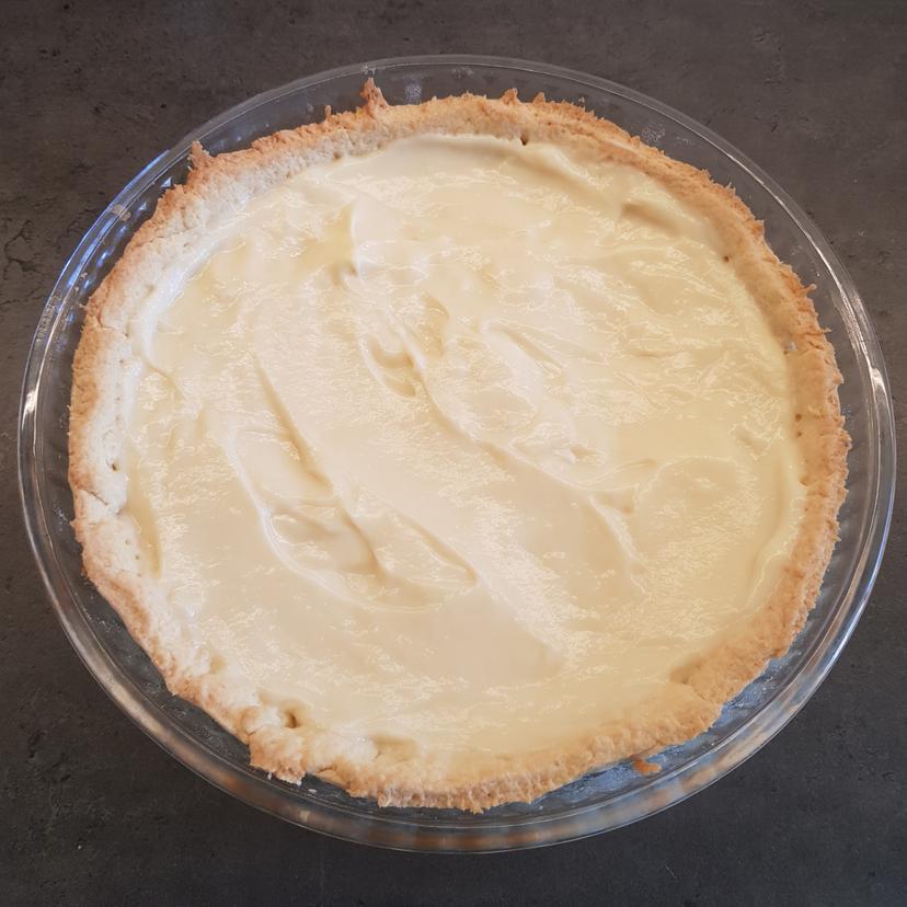 Montage de la tarte aux fruits avec ajout de la crème pâtissière sur le fond de tarte 