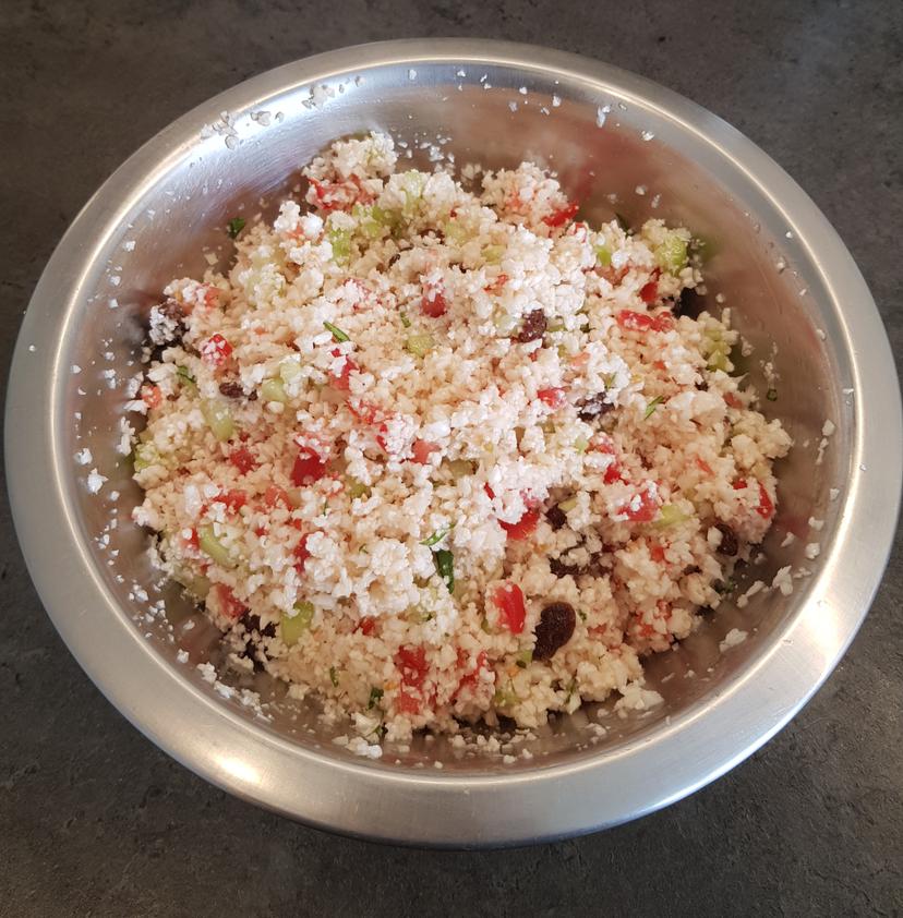 Ensemble des ingrédients du taboulé mélangé et assaisonnement fait avec la vinaigrette. Taboulé dans un saladier, prêt à être dégusté